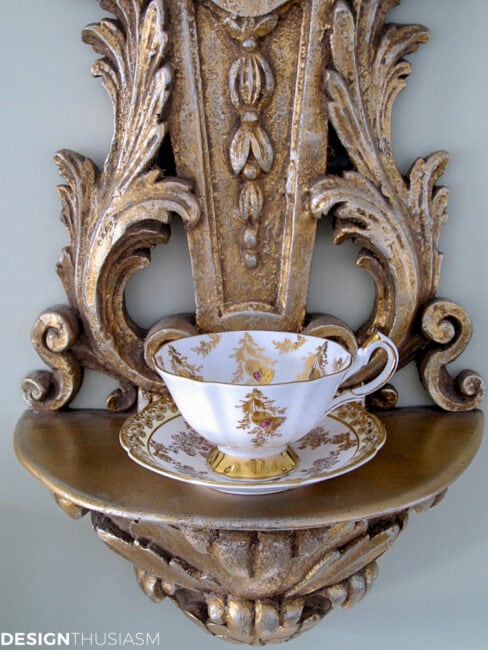 vintage teacup and saucer displayed on a shelf sconce